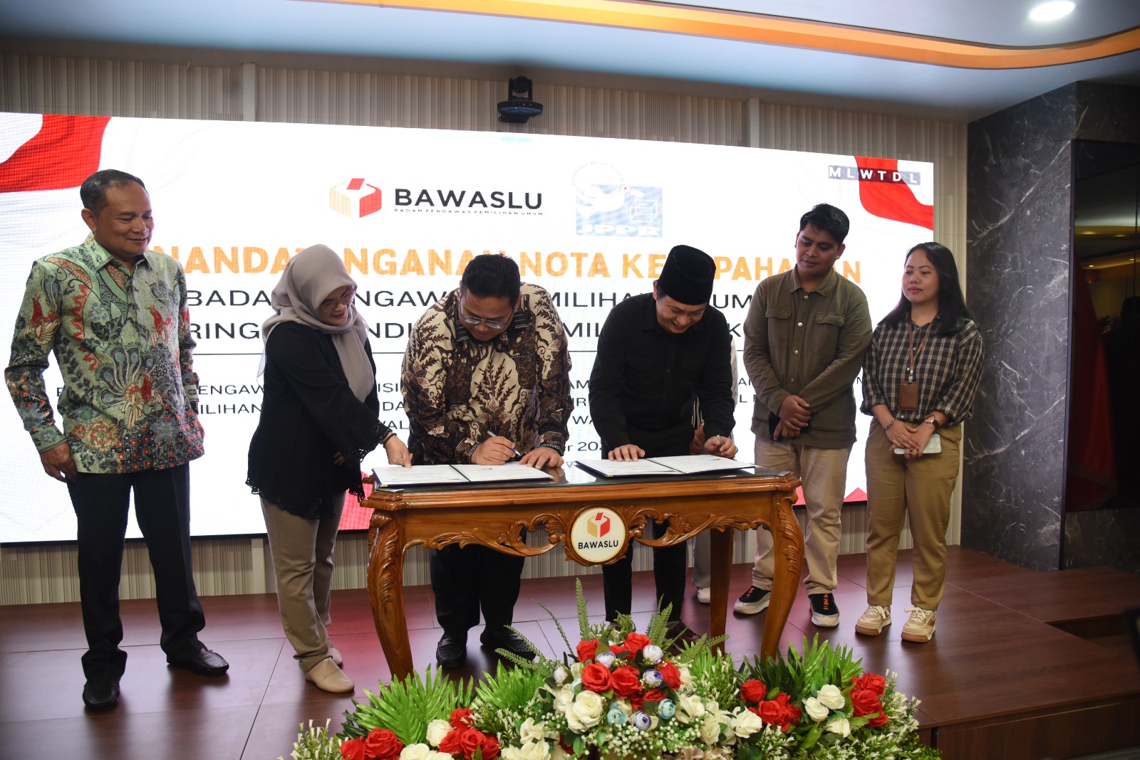 Ketua Bawaslu Rahmat Bagja (ketiga dari kiri) didampingi Anggota Bawaslu Lolly Suhenty (kedua dari kiri) dan Sekretaris Jenderal Bawaslu Ichsan Fuady (kiri) menandatangani MoU dengan empat masyarakat sipil di Kantor Bawaslu, Jakarta, Selasa (29/10/2024).